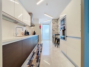 Una cocina moderna con una isla central, electrodomésticos de acero inoxidable y un salpicadero decorativo.