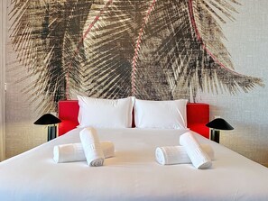 A hotel room with a large bed, two pillows, two bedside tables with lamps, and a large wall tapestry. - MPR The Finnest by Atlantic Holiday (Funchal)