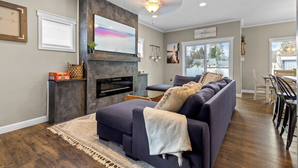 A modern living room with a fireplace, a sofa, and a dining area.