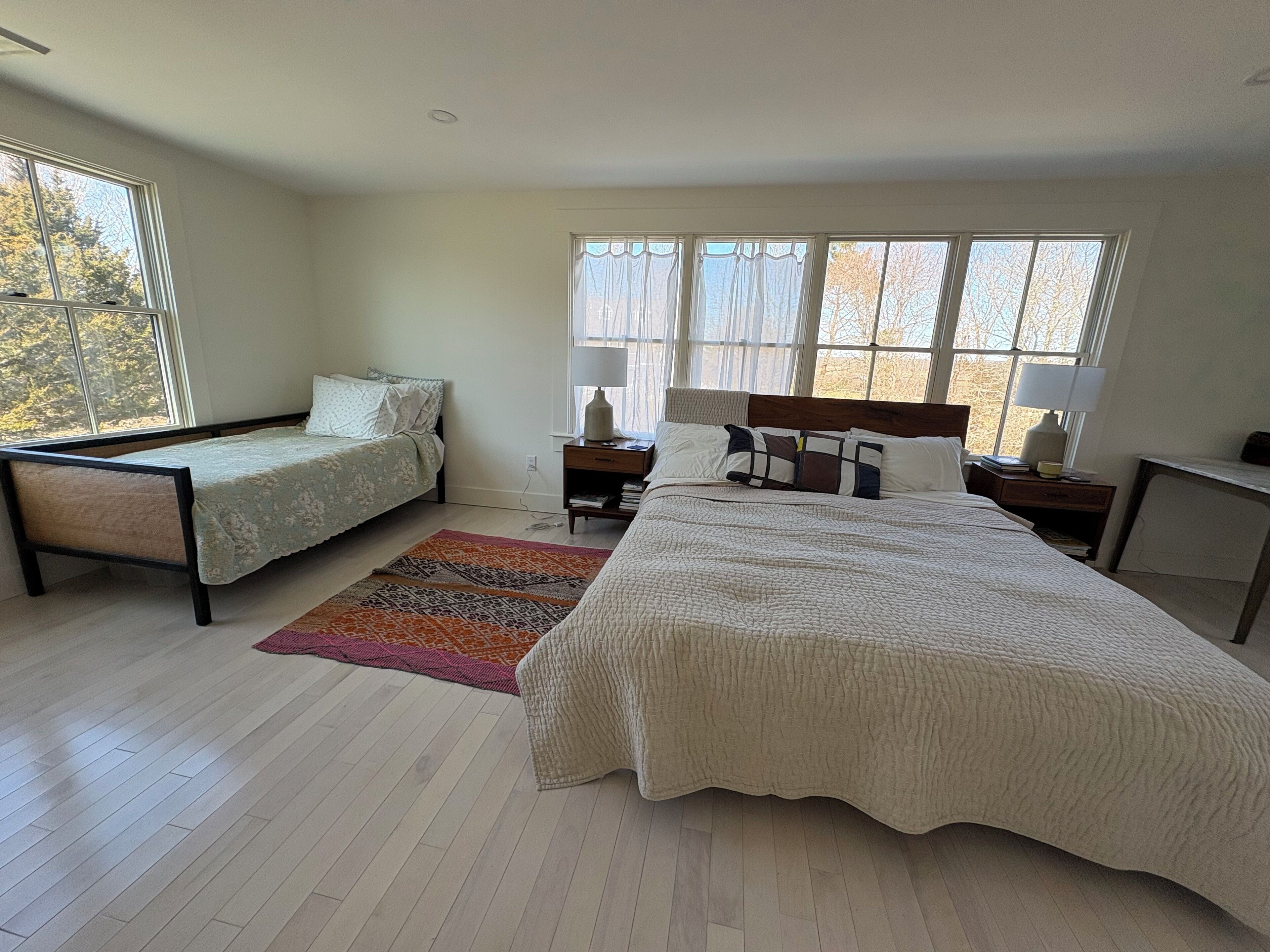 Spacious primary bedroom with king bed, day bed, and peaceful natural light
