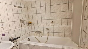 Un baño con ba ñera, ducha y lavamanos.