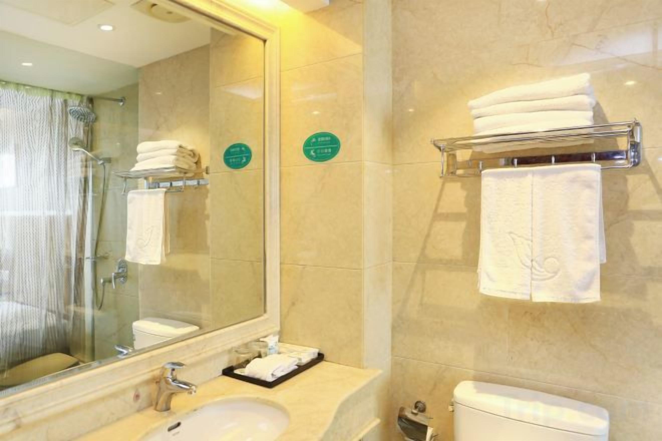A bathroom with a sink, mirror, towel rack, and toilet.