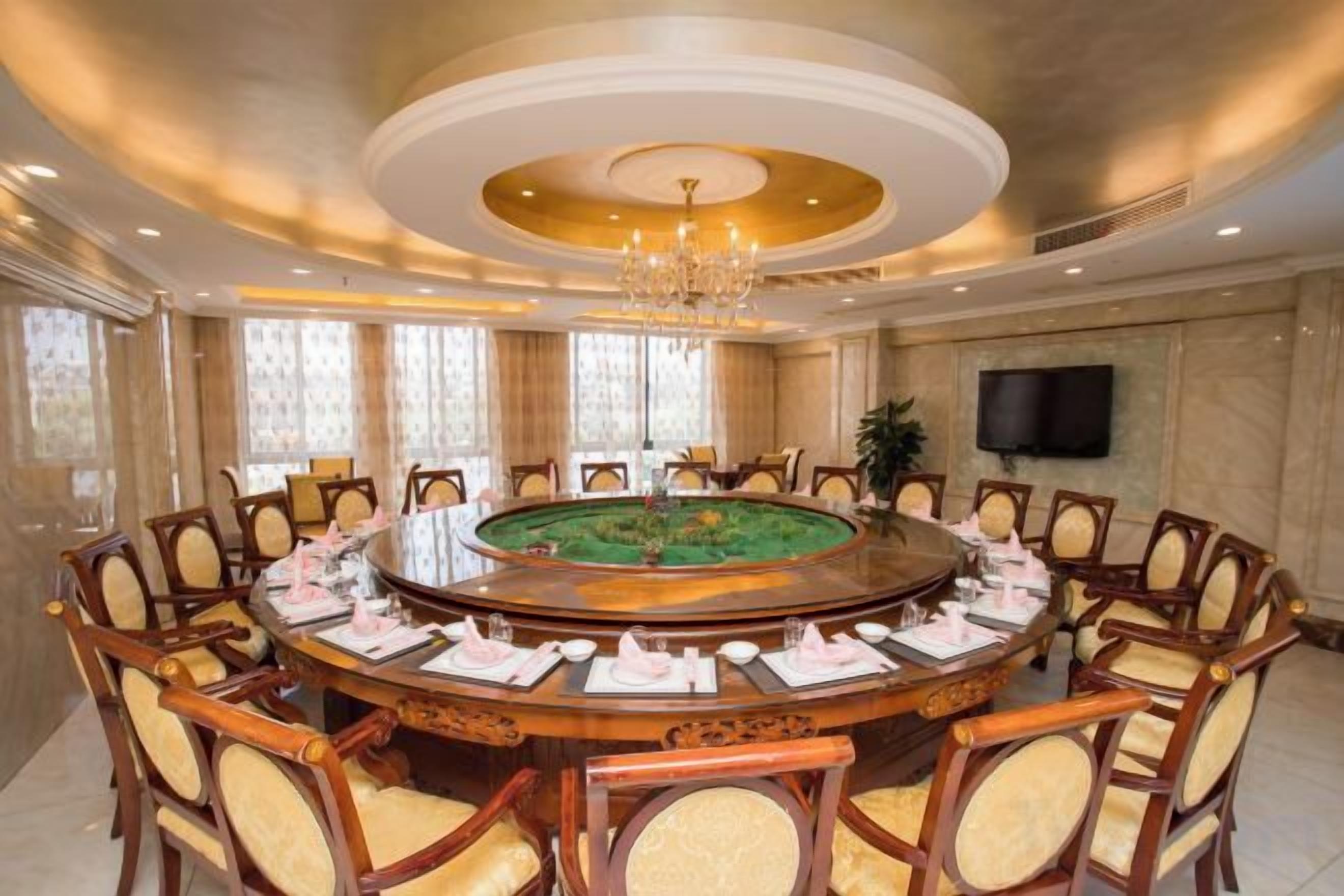 Ein Konferenzraum mit rundem Tisch, Stühlen und einer Chandelier.