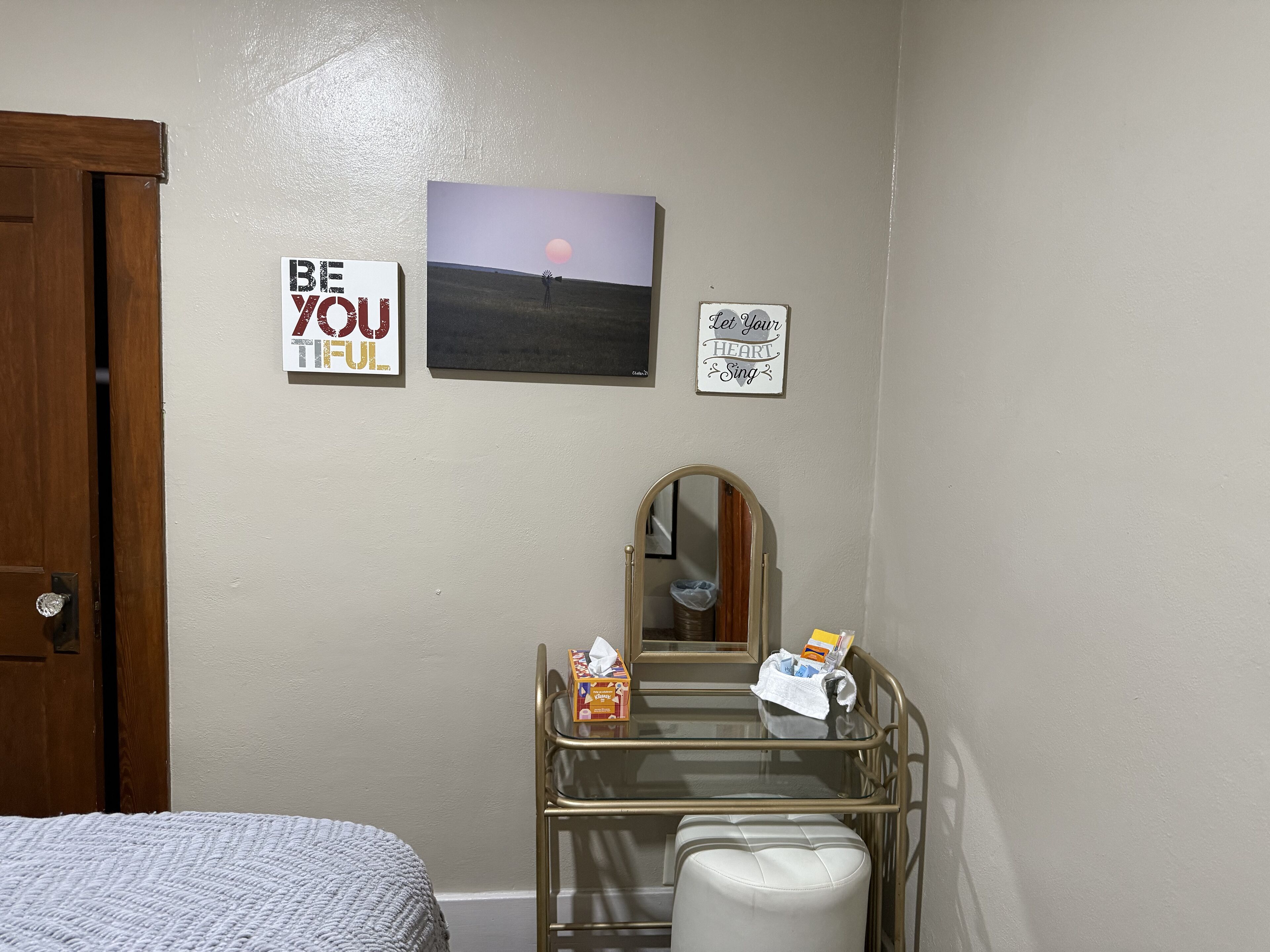 Un dormitorio con cama, cómoda, espejo y decoración mural inspiradora.