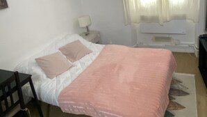 A bedroom with a bed, a chair, a nightstand, a lamp, and a window with curtains. - Magnificent studio Montrouge (Montrouge)