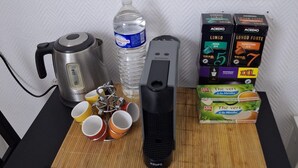 A kitchen counter with a kettle, water bottle, electric kettle, coffee maker, and coffee pods. - Magnificent studio Montrouge (Montrouge)