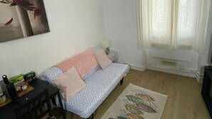 A small, cozy room with a sofa, a small table, and a rug. - Magnificent studio Montrouge (Montrouge)
