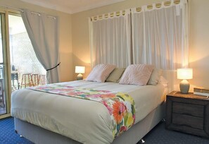 A hotel room with a bed, two bedside lamps, a nightstand, and a view of the outside. - Relaxing waterfront property with own jetty and magnificent views (Amity Point)