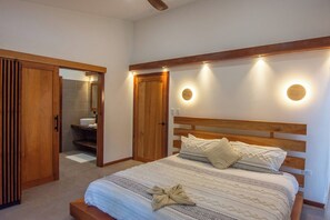 A bedroom with a wooden bed, a bedside table, a mirror, and a wooden wardrobe.