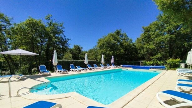Ein Schwimmbecken mit Liegestühlen und Sonnenschirmen.