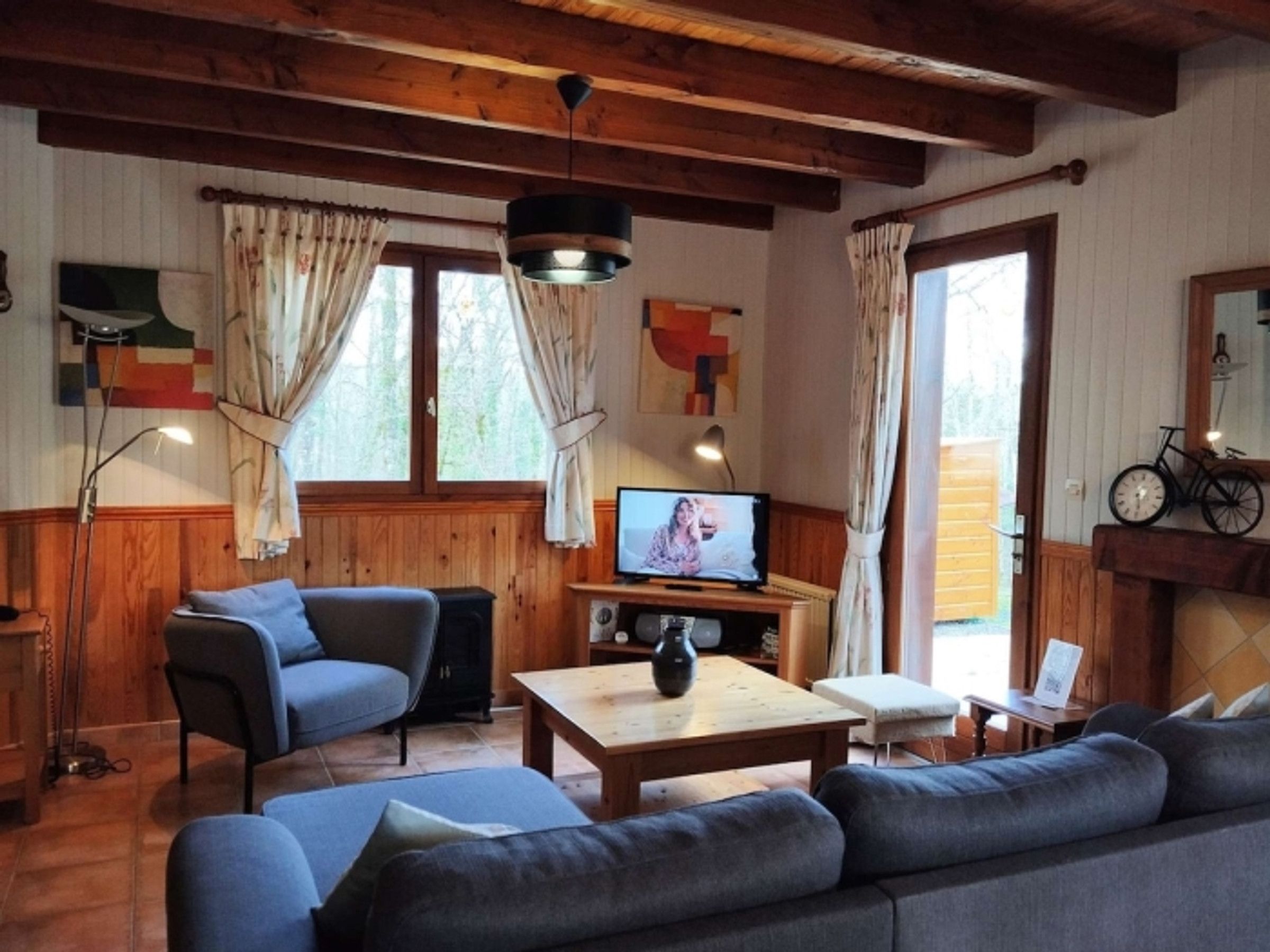 Ein gemütliches Wohnzimmer mit einer Couch, einem Fernseher und einem Holztisch.