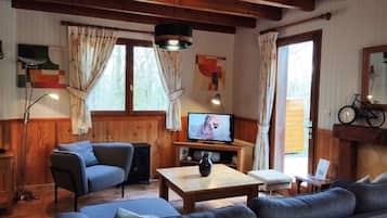 A cozy living room with a sofa, a television, and a wooden coffee table.