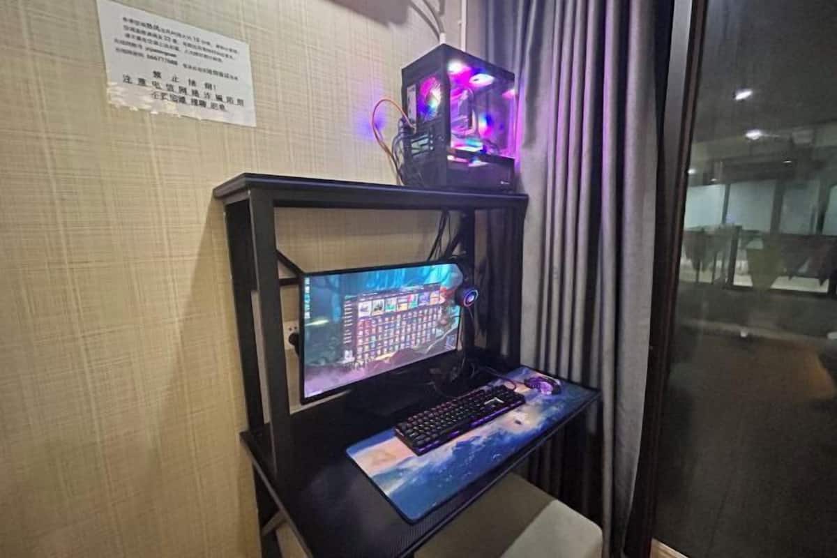 Ein Gaming-PC-Setup mit Monitor, Tastatur und RGB-Beleuchtung auf einem Schreibtisch.