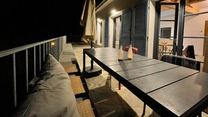 A balcony with a table, chairs, and a sofa. There are two bottles on the table. - Air-conditioned villa with pool and panoramic sea view, 6 pax (Brando)