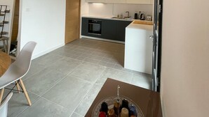 A modern kitchen with white cabinets, a built-in oven, and a small island with a sink. - Air-conditioned villa with pool and panoramic sea view, 6 pax (Brando)