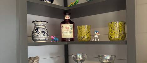 A shelf with various decorative items including vases, a bottle, and figurines.