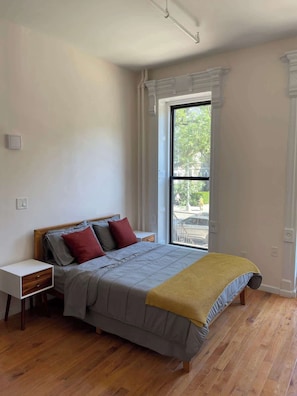 Una camera da letto con un letto, un comodino, una finestra e vista sull'esterno.