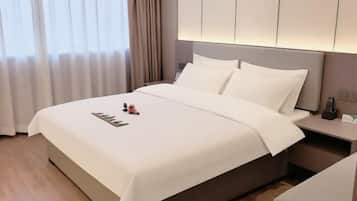 A hotel room with a large bed, a bedside table, and a nightstand.