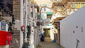A narrow cobblestone alley with buildings on either side, a mailbox, and a sign that reads "Hello World". - Helloworld guesthouse (Seoul)