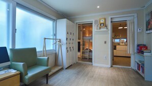 A room with a desk, a chair, a wardrobe, a closet, and a kitchen area. - Helloworld guesthouse (Seoul)