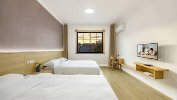 Een hotelkamer met twee bedden, een televisie, een bureau en een raam met uitzicht.