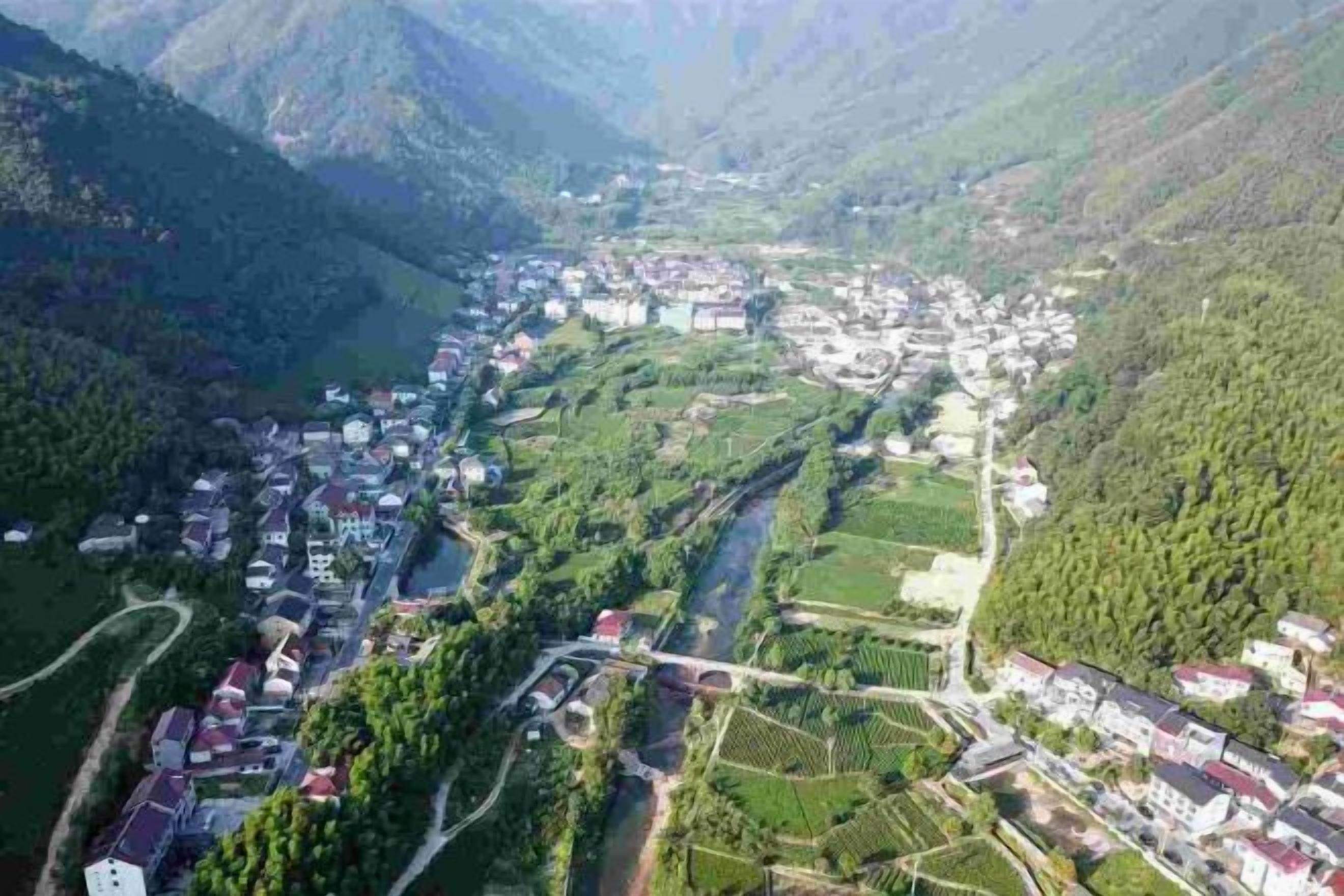 A mountainous village with houses and terraced fields.