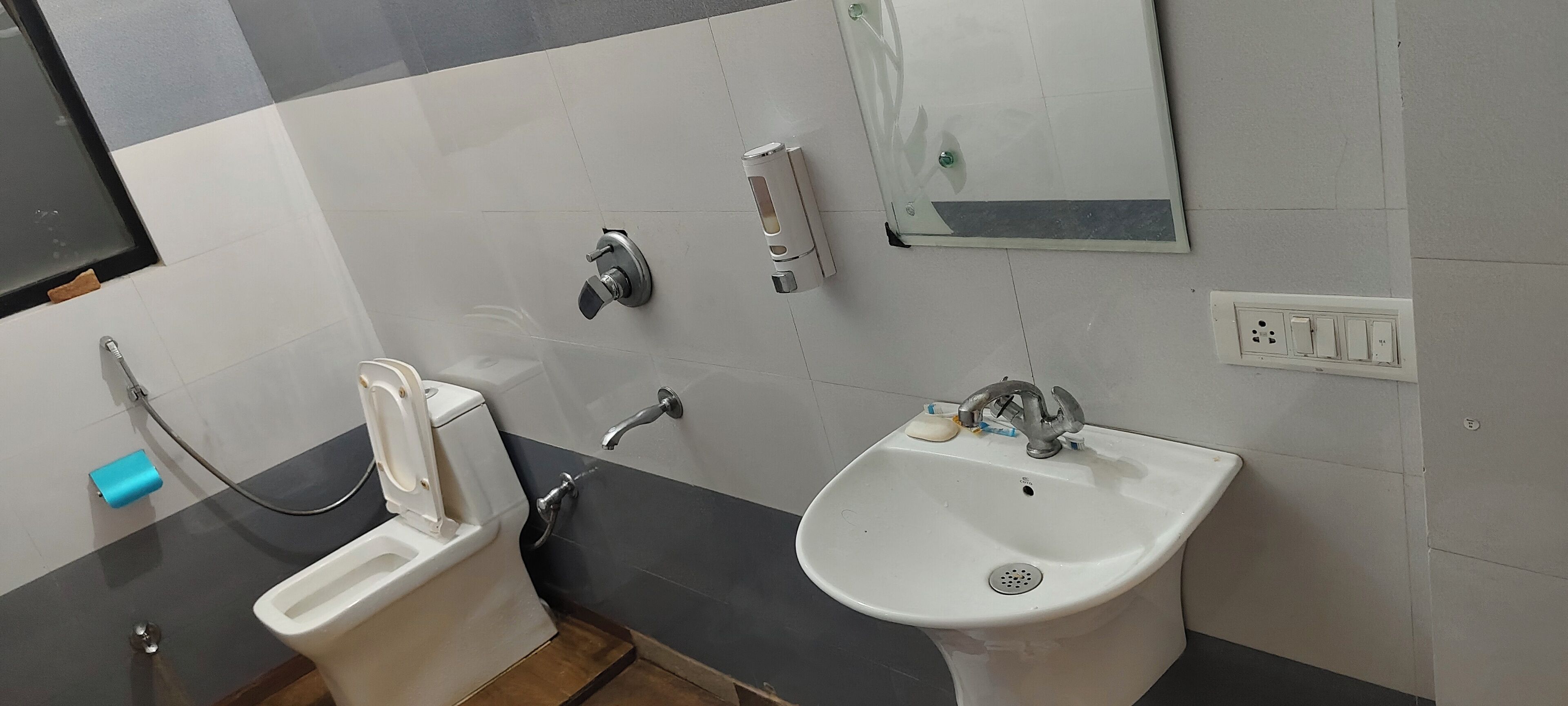 Un baño con inodoro, bidé, lavabo y espejo.