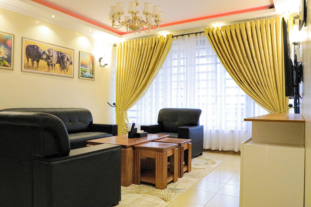 A living room with a sofa, armchairs, a coffee table, and a water dispenser.