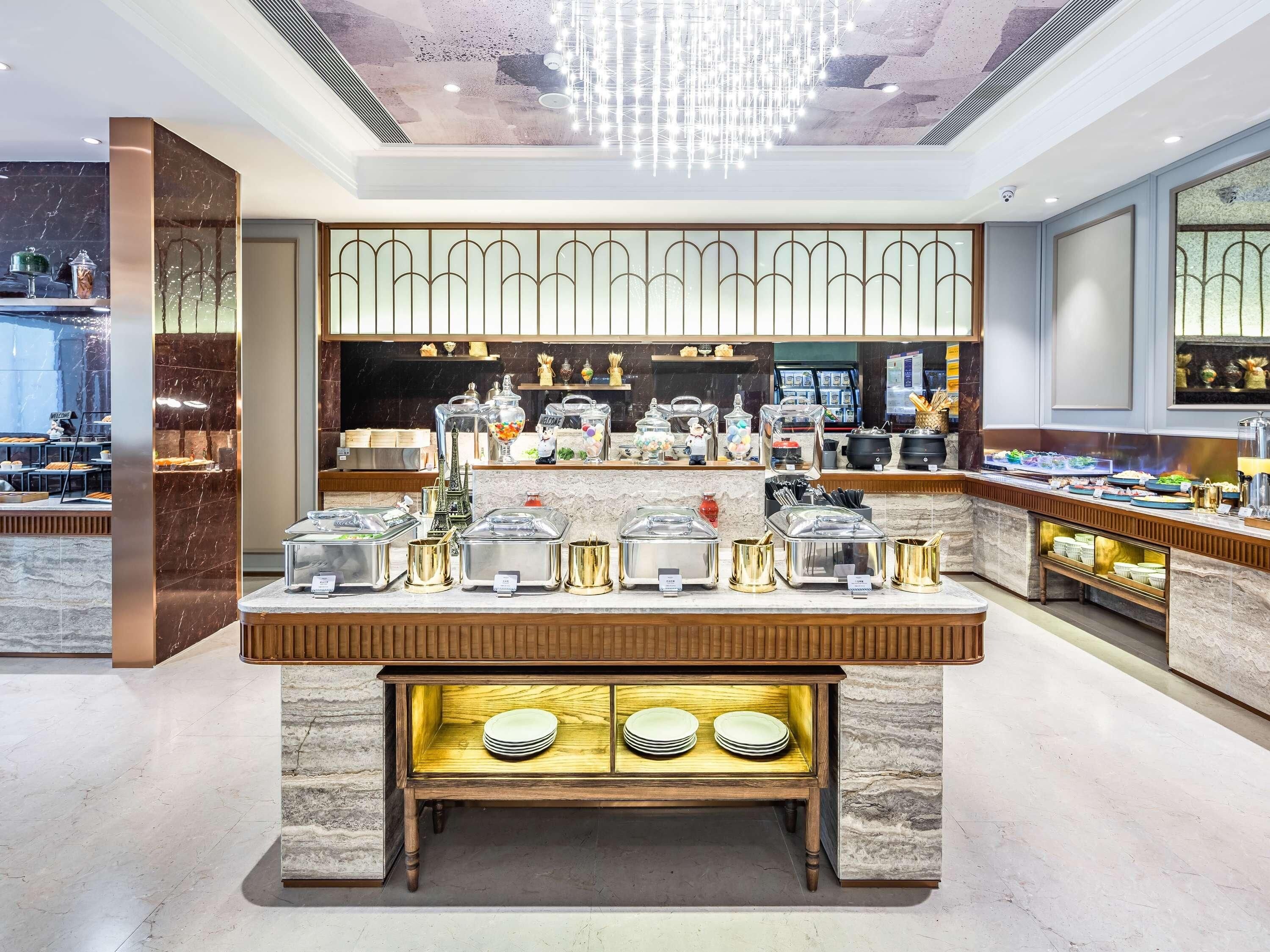A well-lit buffet area with marble countertops, a variety of food containers, and a decorative Eiffel Tower centerpiece.