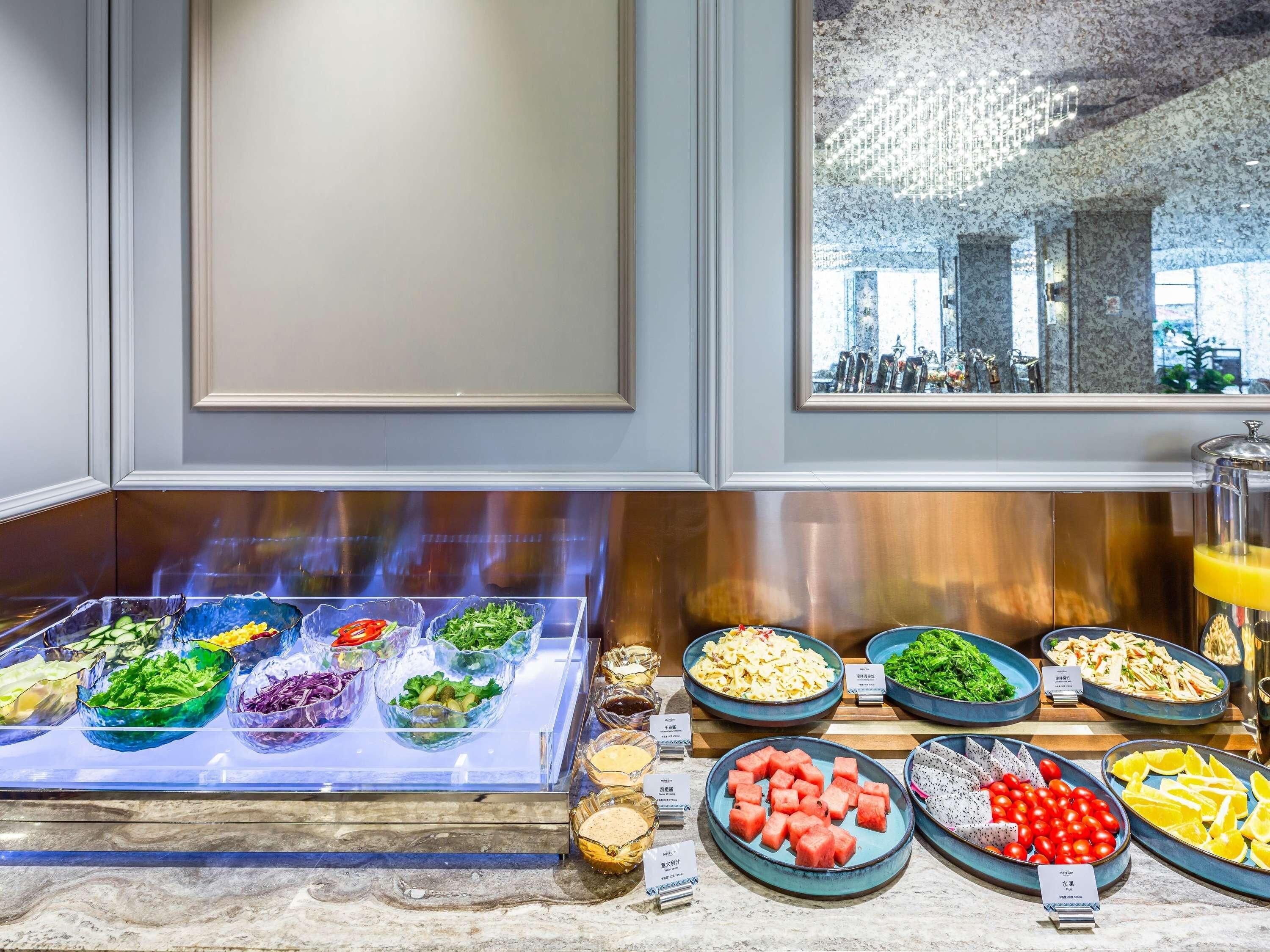 A buffet with various food items including salads, fruits, and vegetables.