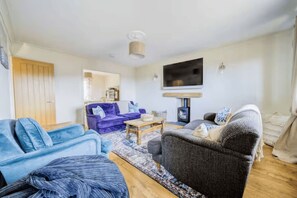 A living room with a sofa, armchair, and a coffee table. - Charming family escape near Calshot Beach & New Forest (Calshot)
