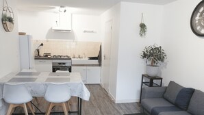 Un espacio habitable compacto con comedor, cocina y zona de estar.