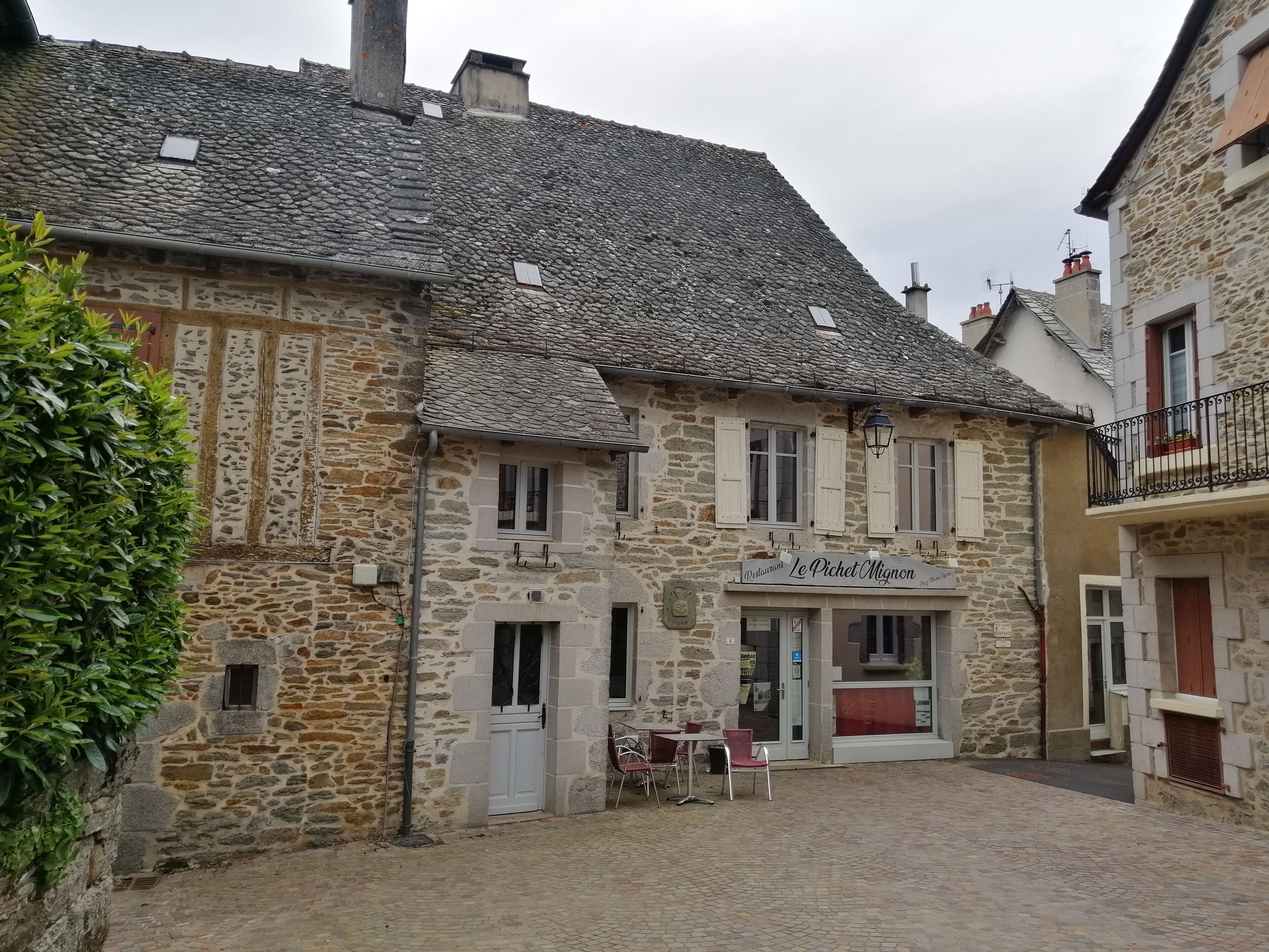 A stone building with a sign for 'Le Picket Mignon' restaurant.
