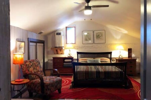 A bedroom with a bed, a chair, a dresser, and a lamp. - Red Fox Ridge Cabin Retreat - No Cleaning Fee. Relax and unwind (Butler)