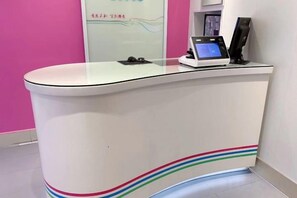 A reception desk with a glass top, a digital screen, and a telephone. - 100 Inn (Shanghai Changhai Hospital & Xiangyin Road Metro Station) (Shanghai)