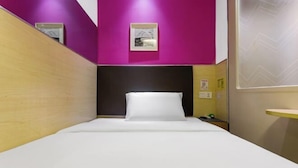 A small, brightly colored hotel room with a bed, a headboard, and a small shelf. - 100 Inn (Shanghai Changhai Hospital & Xiangyin Road Metro Station) (Shanghai)