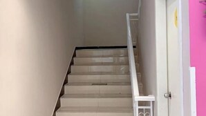 A staircase with a white handrail and beige steps, leading to a door with a yellow sign. - 100 Inn (Shanghai Changhai Hospital & Xiangyin Road Metro Station) (Shanghai)
