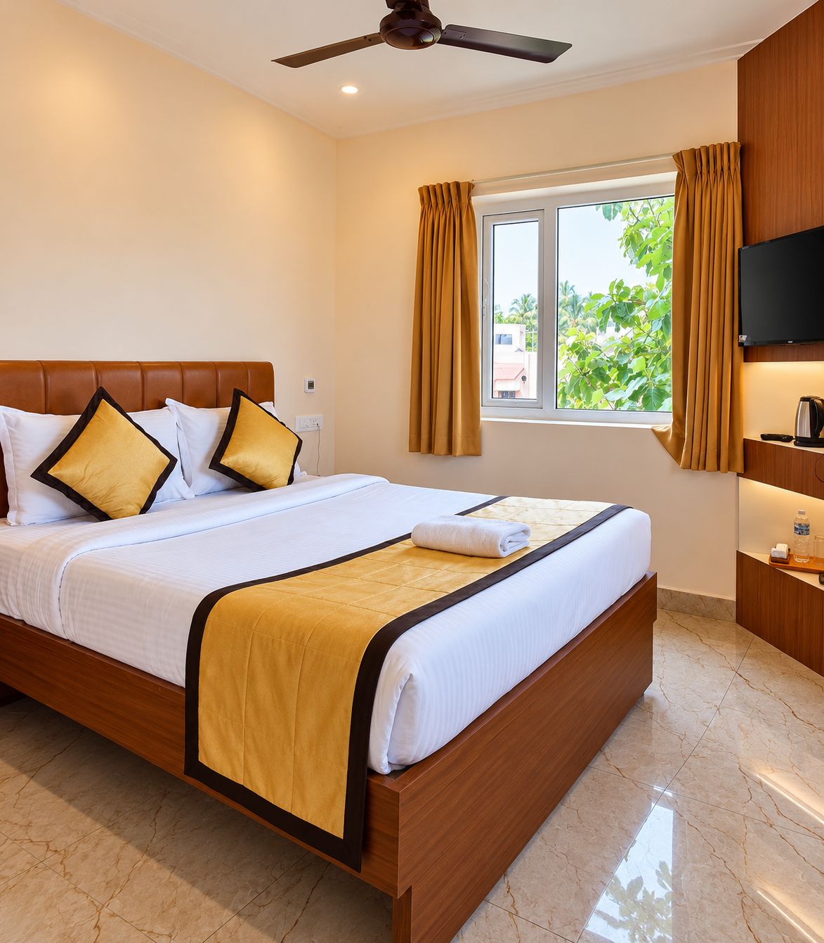 Una habitación de hotel con cama, televisión, ventana con cortinas y ventilador de techo.