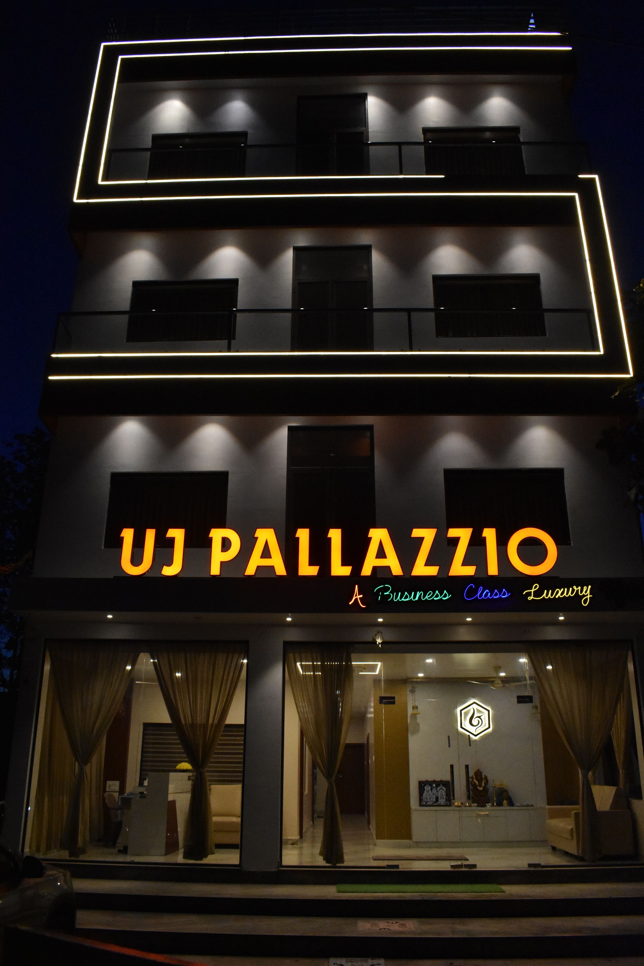 A multi-story building with illuminated signage reading 'UJ PALLAZZO A Business Class Luxury.'