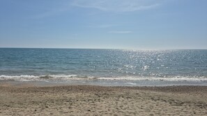 A beach with a pebbly shore and calm sea under a clear sky. - Tristan Vacation Home (Lazio)