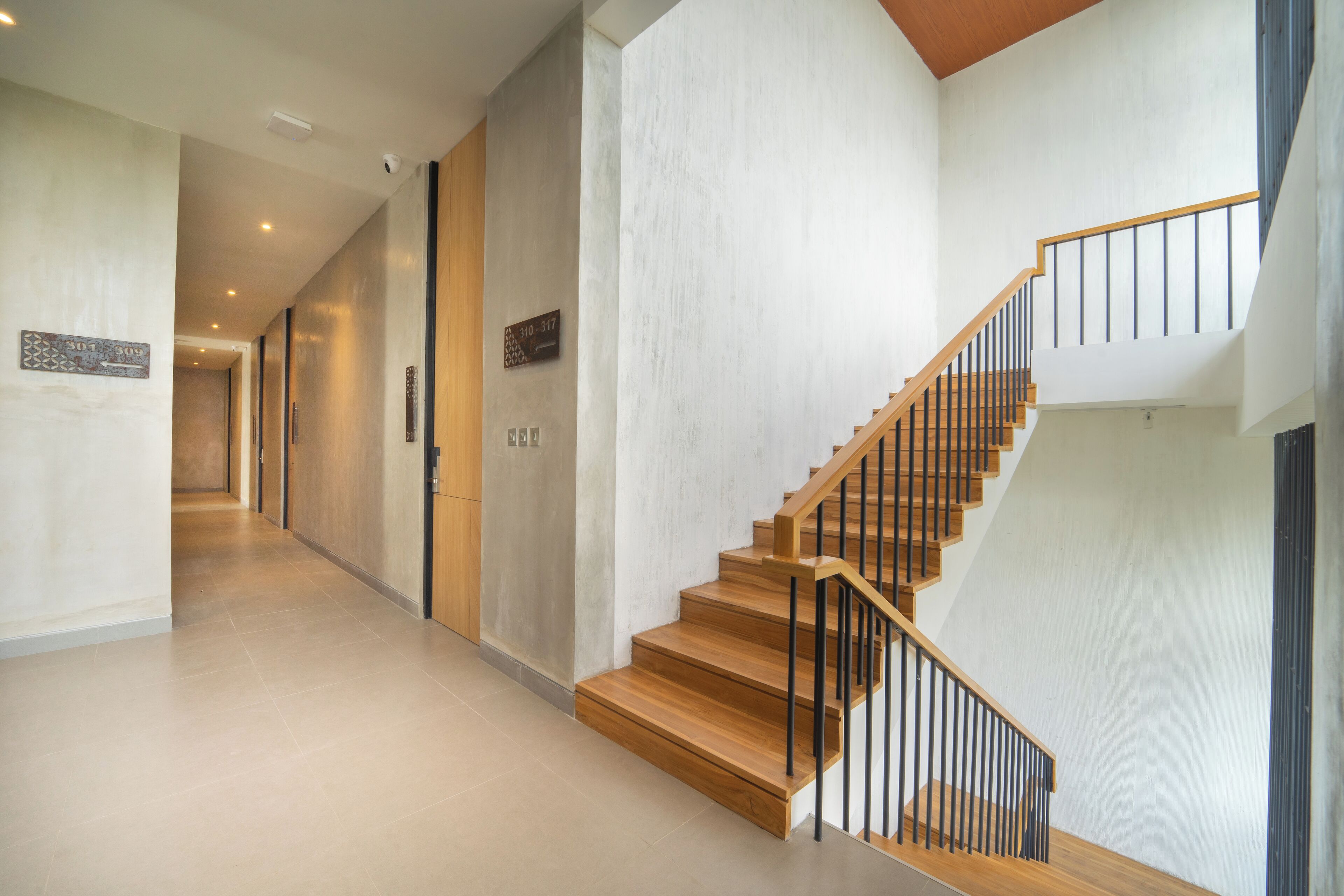 Ein modernes Interieur mit einer Holztreppe und einem langen Flur.