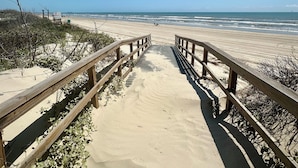 A wooden boardwalk leading to a sandy beach with a clear blue sky. - Luxury Oceanfront Oasis, Private Pool, Steps to Beach (Port Aransas)