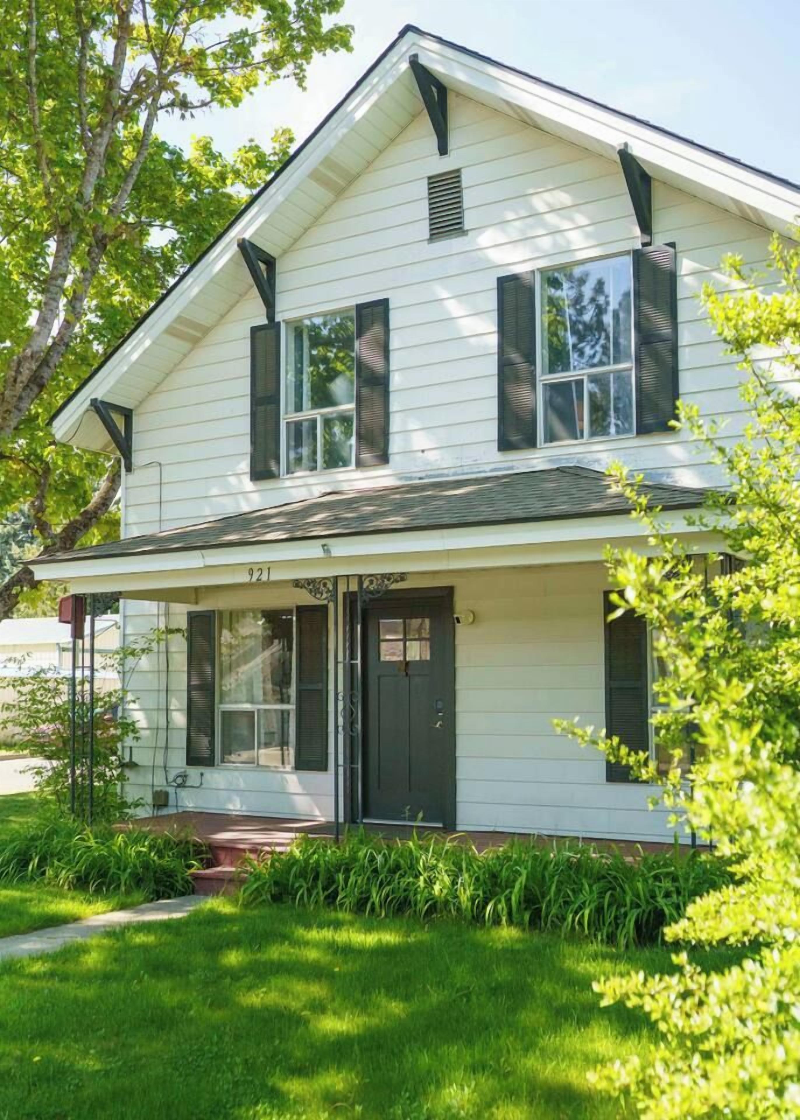 A two-story house with a front porch, a visible number '921' on the front, and a well-maintained lawn.