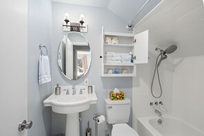 A modern bathroom with a white sink, mirror, toilet, and shower. - Heated Pool & Hot Tub | Modern Family Retreat (Coeur d'Alene)