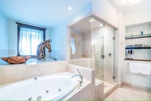 Une salle de bain moderne avec une baignoire sur pieds, une douche à parois de verre et un meuble-lavabo avec des étagères.
