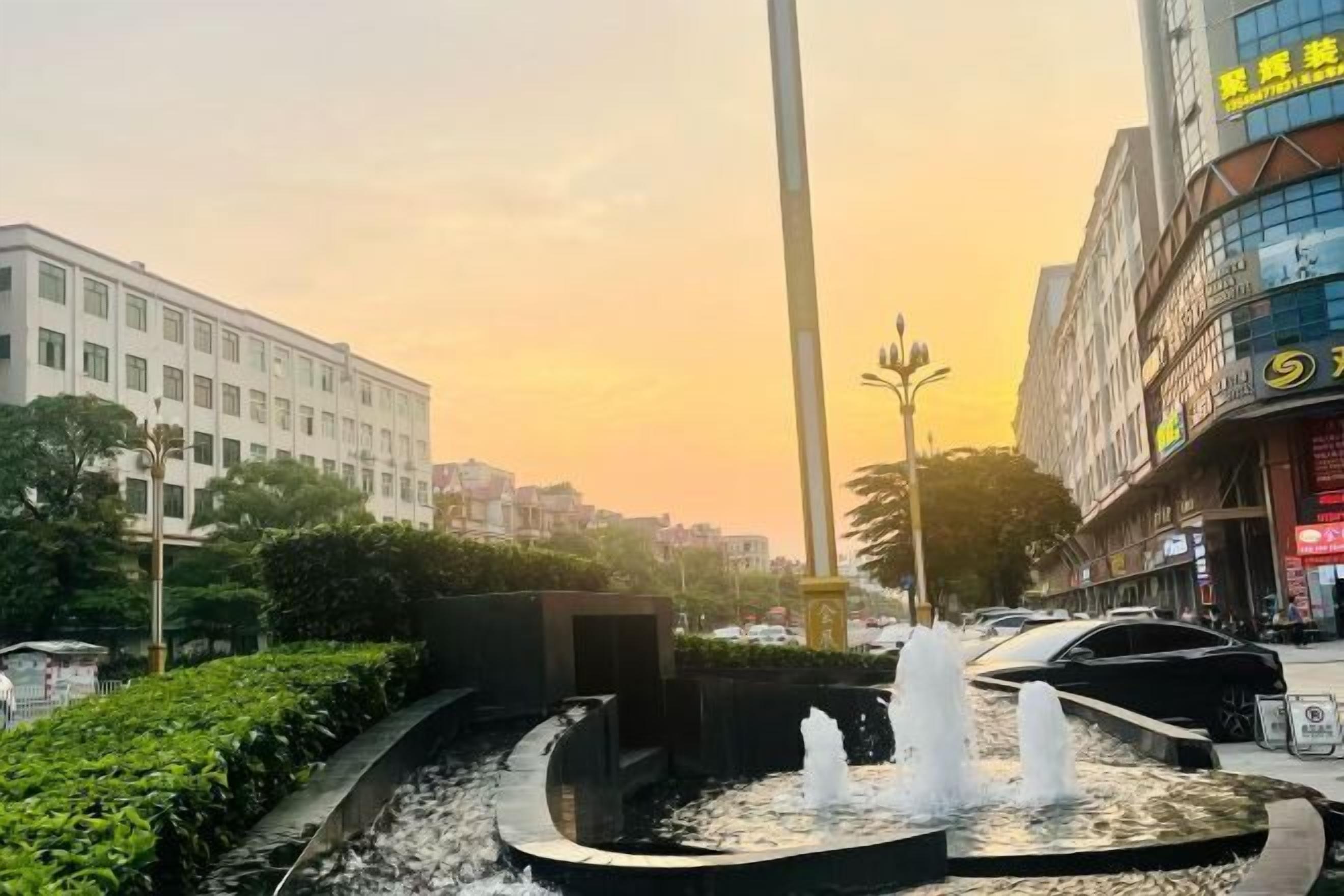 A fountain in an urban setting with buildings in the background.