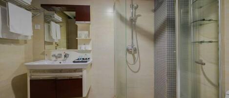 A bathroom with a glass-enclosed shower, a sink with a mirror, and a towel rack.