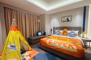 A hotel room with a bed featuring a duck-themed bedspread, a gray sofa, a small table, and a tent-like structure. - Xiamen Jingbang Hotel (Xiamen)