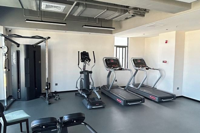 Een moderne sportschool met loopbanden, elliptische trainers en gewichtbanken.