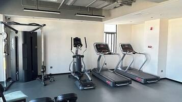 Een moderne sportschool met loopbanden, elliptische trainers en gewichtbanken.